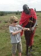 tips and tricks being passed down from a masai moran to a tourist kid